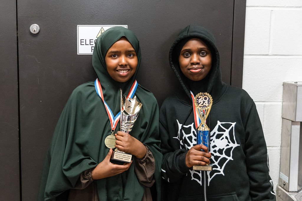 Middle School debaters pose with trophies.