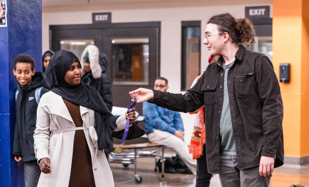 Debater accepts award from AmeriCorps member