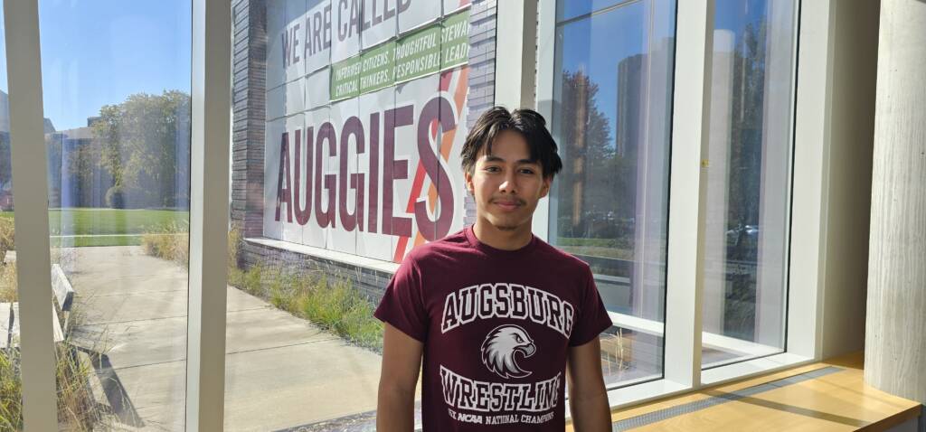 Jose smiles wearing Augsburg merchandise