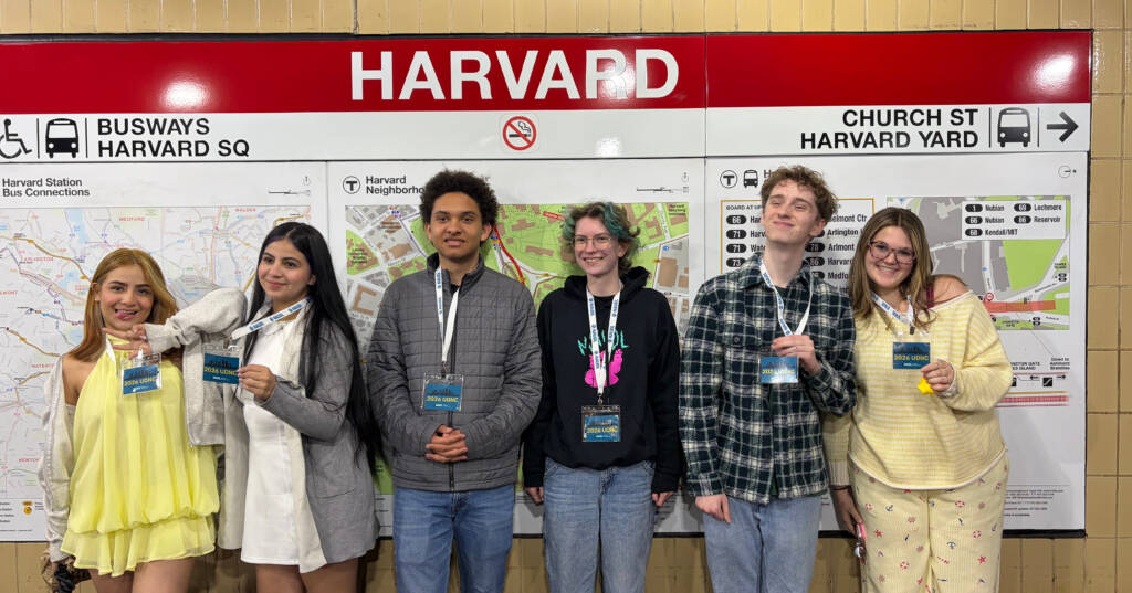 Debaters pose in front of Harvard stop