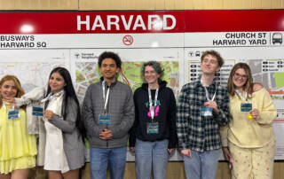 Debaters pose in front of Harvard stop