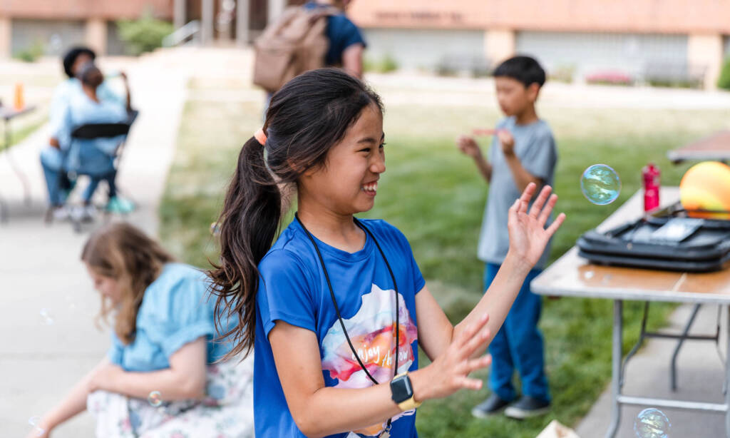Debate camper playing with bubbles