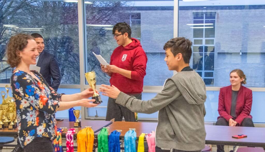 Program Manager presents debater with trophy.